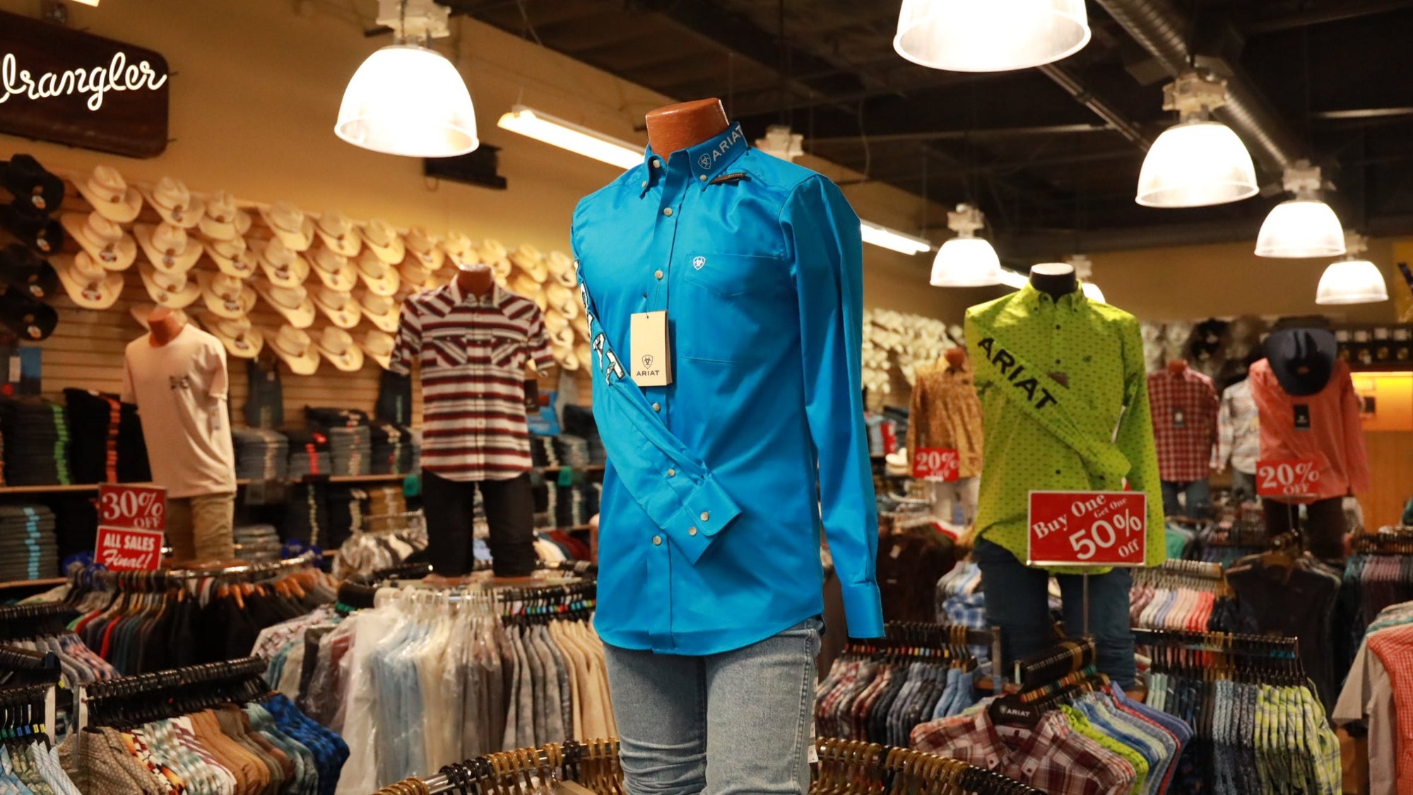 Mannequin wearing a blue shirt in a clothing store with Wrangler branding.