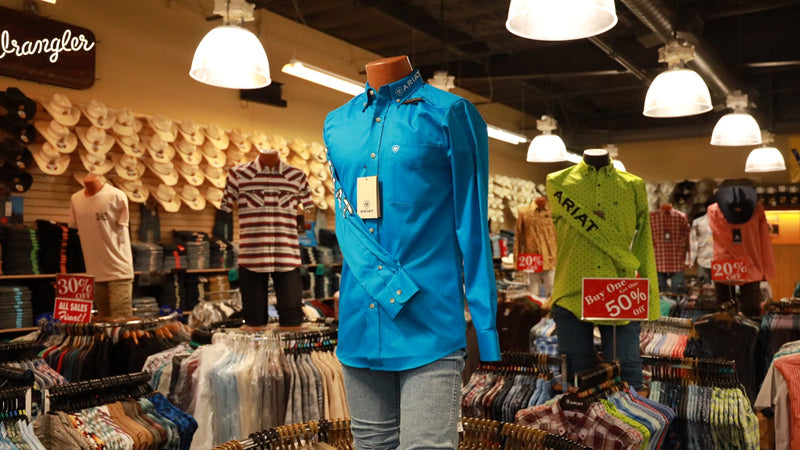 Mannequin wearing a blue shirt in a clothing store with Wrangler branding.